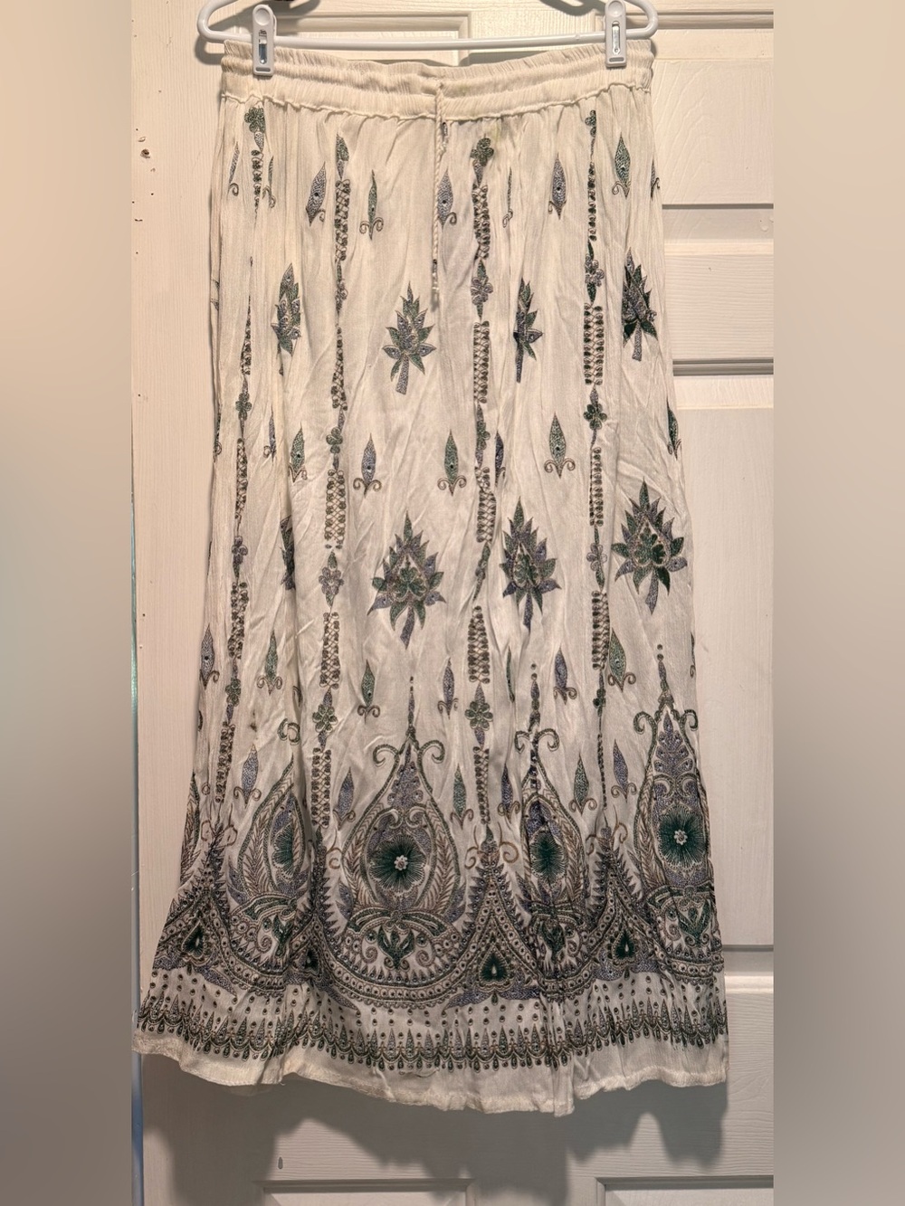 Embroidered white maxi skirt with green accents.